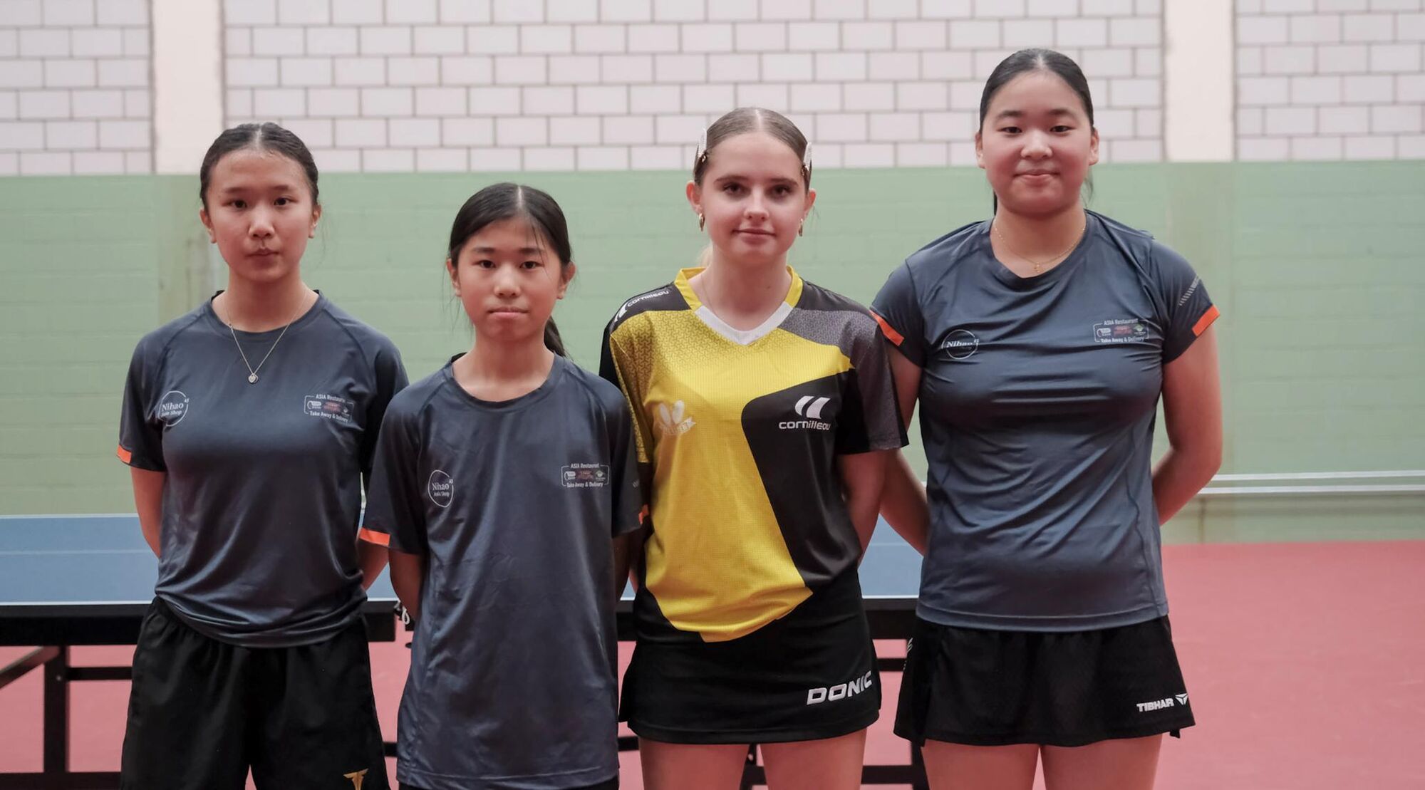 Vier junge Spielerinnen in Trikots nebeneinander